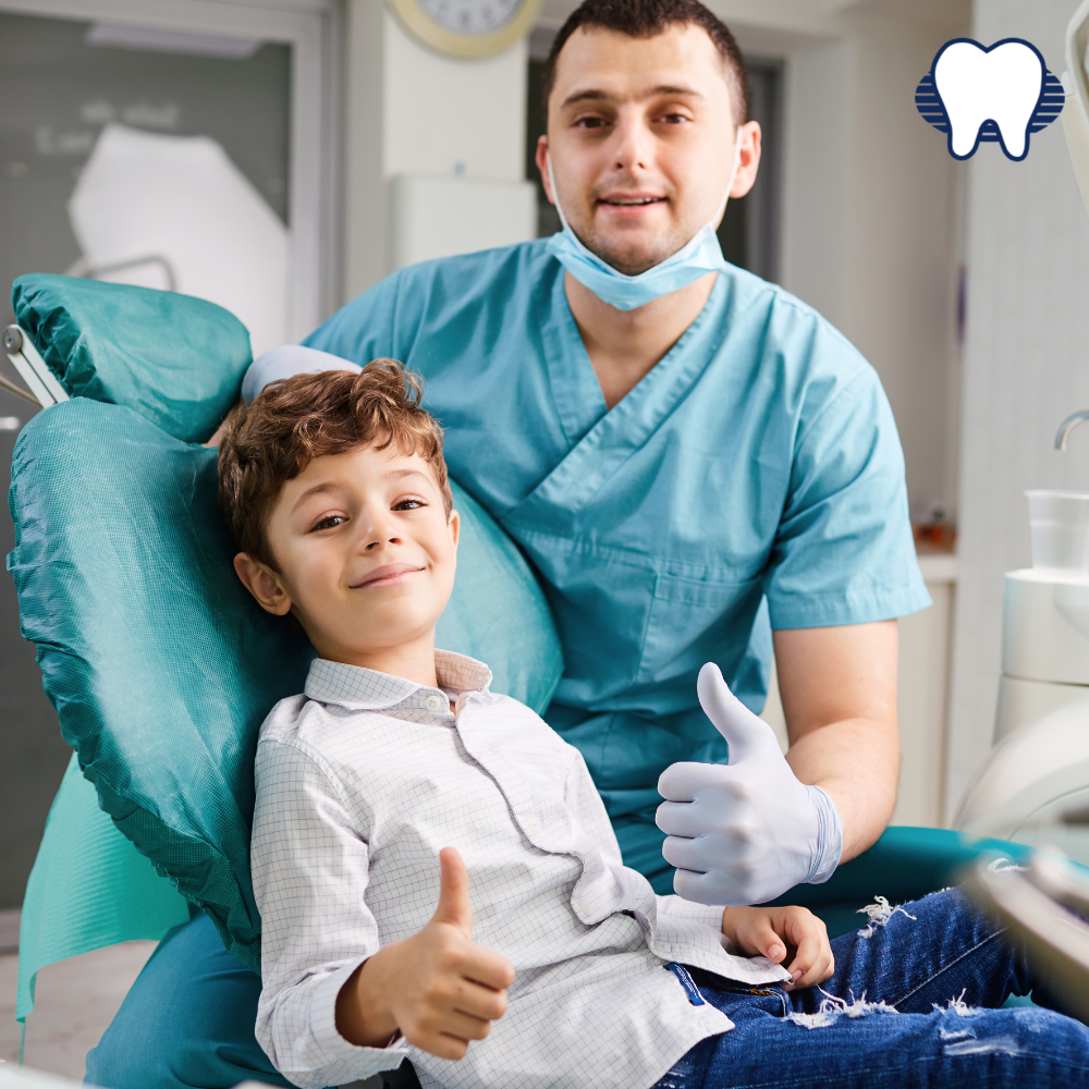 Dentist smiling and thumbs up with young boy 